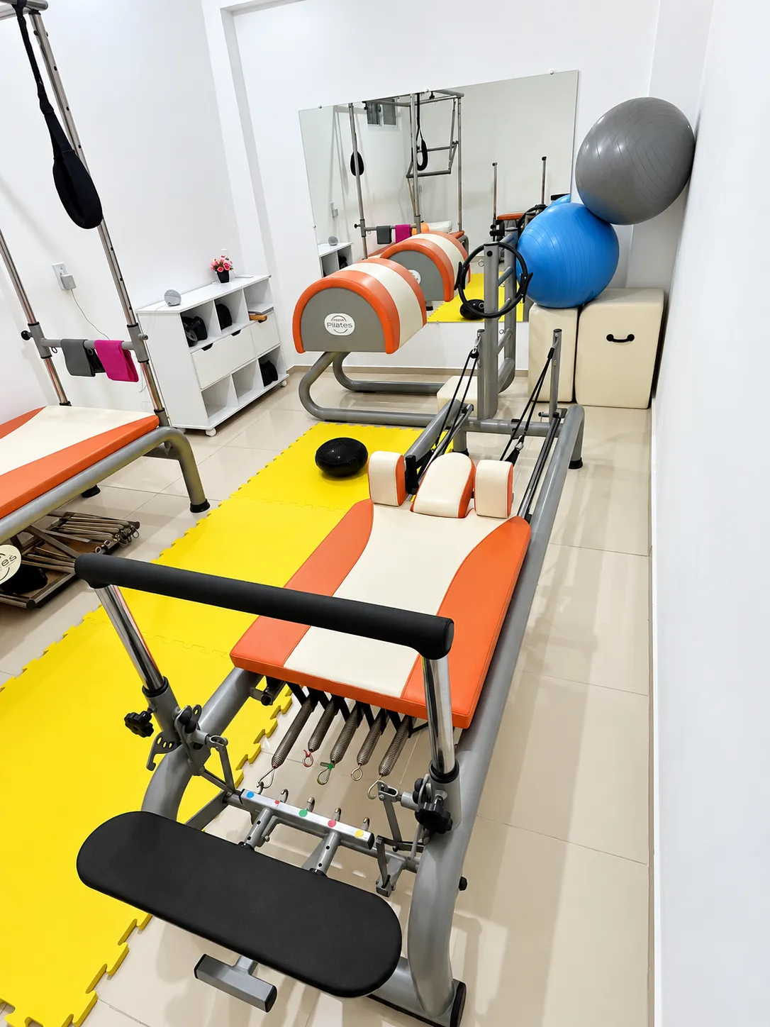 Sala do Studio Pilates Costa Martins com reformer, cadillac e bolas de exercício